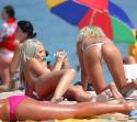 195Two_platinum_blonde_women_in_string_thong_bikini_are_shown_in_this_candid_pic.